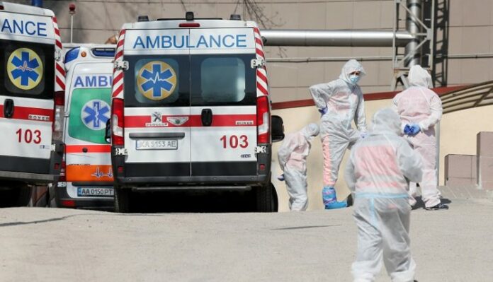 FILE PHOTO: Medical personnel stand next to ambulances with COVID-19 patients in Kyiv